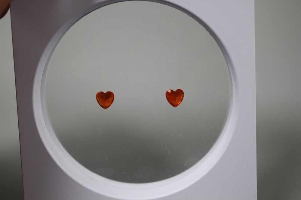 A near pair of unmounted heart shaped fire opals, each weighing approximately 0.90ct.